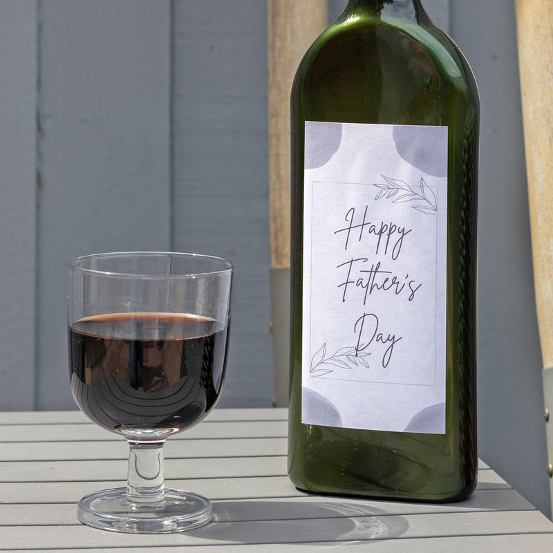 Letterbox-friendly wine bottle with a Happy Father's Day label next to a glass of red wine