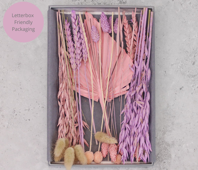 Pastel pink, purple and natural dried flower bouquet arranged in a letterbox-friendly gift box