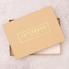 Yellow kraft gift box with 'letterbox gifts' in gold foil