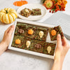 Halloween rocky road chocolate brownies with green stripey icing and chocolate pumpkins, bats & skulls in a letterbox-friendly gift set