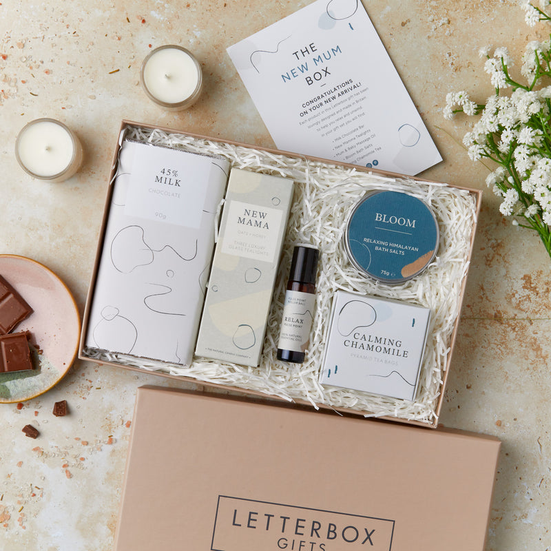 Letterbox-friendly new mum gift set containing milk chocolate, tealights, aromatherapy oil roll on, calming chamomile tea and bath salts