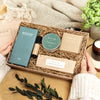 Relaxation gift set containing honeycomb chocolate bar, restore bath salts, darjeeling tea, aromatherapy oil roll on and black pomegranate tealights in green and kraft packaging