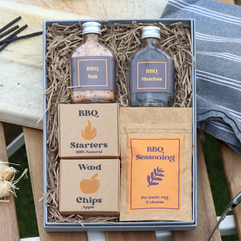 BBQ letterbox gift set containing Kraft boxes of BBQ starters & wood chips, glass bottles of BBQ salt and matches and a pouch of BBQ seasoning
