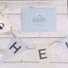 a blue envelope with the words hello baby bunting kit above some bunting on string
