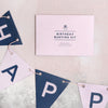 Birthday bunting kit in navy and pink next to a pink envelope