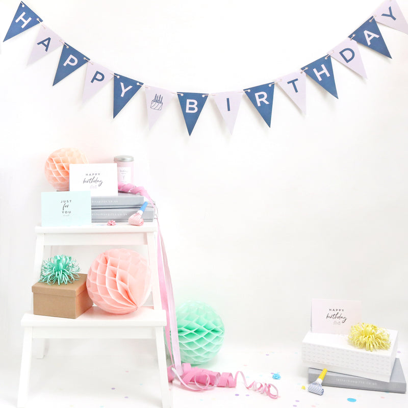 Navy and pink happy birthday bunting displayed on wall  with festive decorations