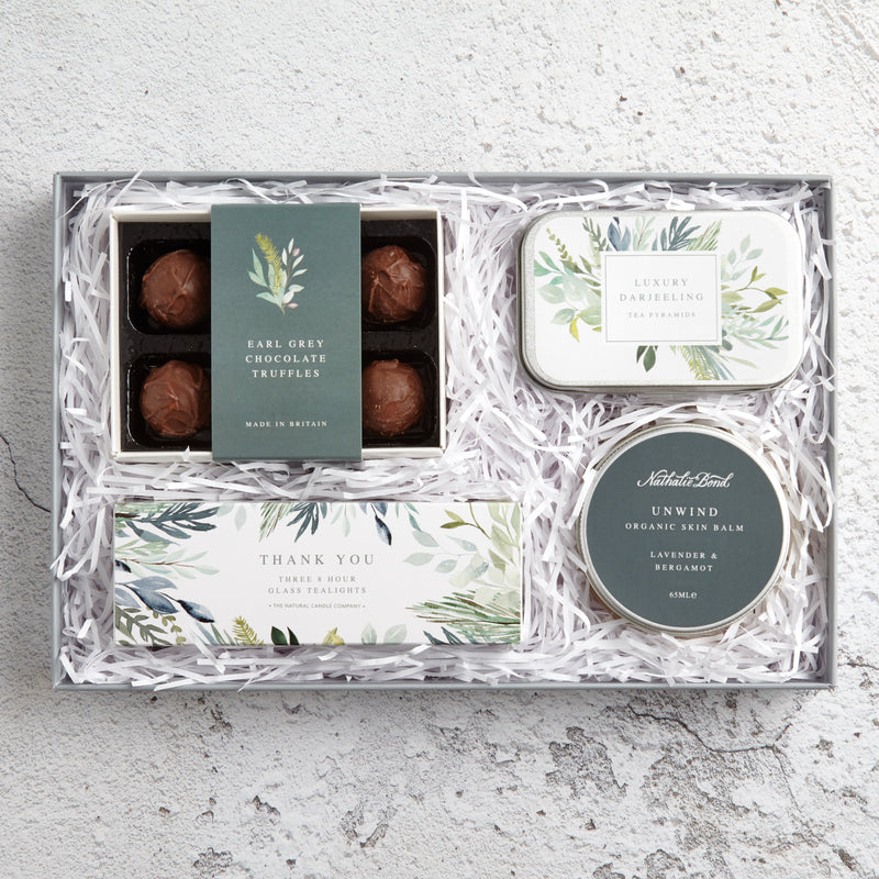 Thank You letterbox gift set containing earl grey chocolate truffles, darjeeling tea tin, unwind skin balm & thank you tealights