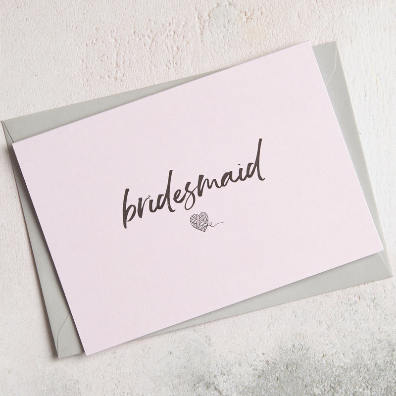 A6 pastel pink greetings card with Bridesmaid text in handwriting font and a heart image