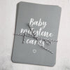 Grey baby milestone card set neatly tied with grey and white string