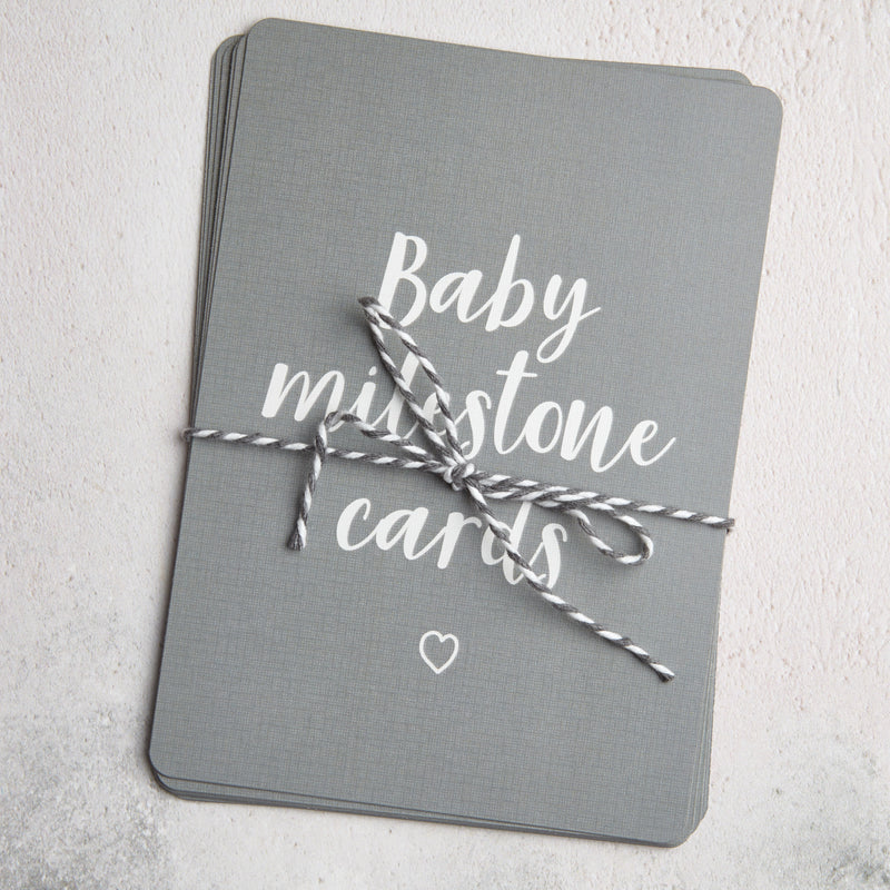 Grey baby milestone card set neatly tied with grey and white string