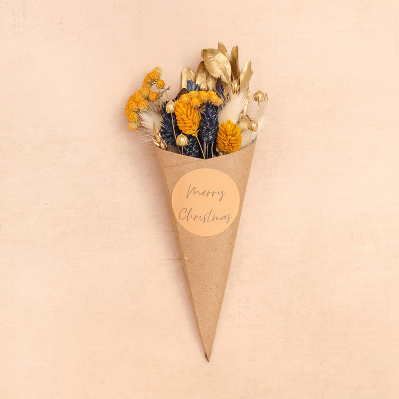 Christmas dried flower posy containing gold, blue, yellow & white flowers with a 'merry christmas' label