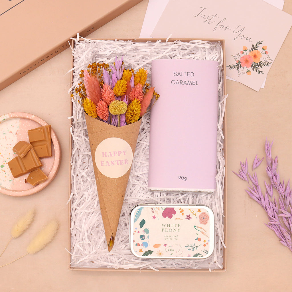 Easter floral letterbox gift set containing salted caramel chocolate bar, white peony loose leaf tea tin and pink, purple and yellow pastel dried flower posy in kraft cone with happy easter sticker