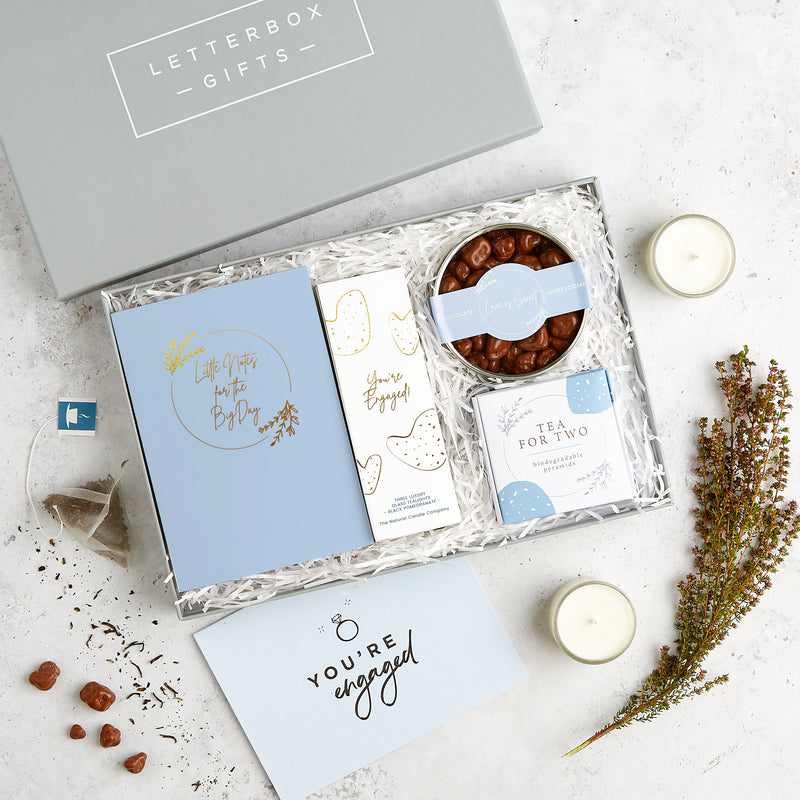 Engagement gift set in blue and white containing wedding planner notebook, chocolate honeycomb, Darjeeling tea for two box and You're Engaged tealights