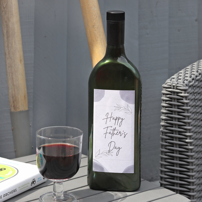 Letterbox-friendly wine bottle with a Happy Father's Day label next to a glass of red wine