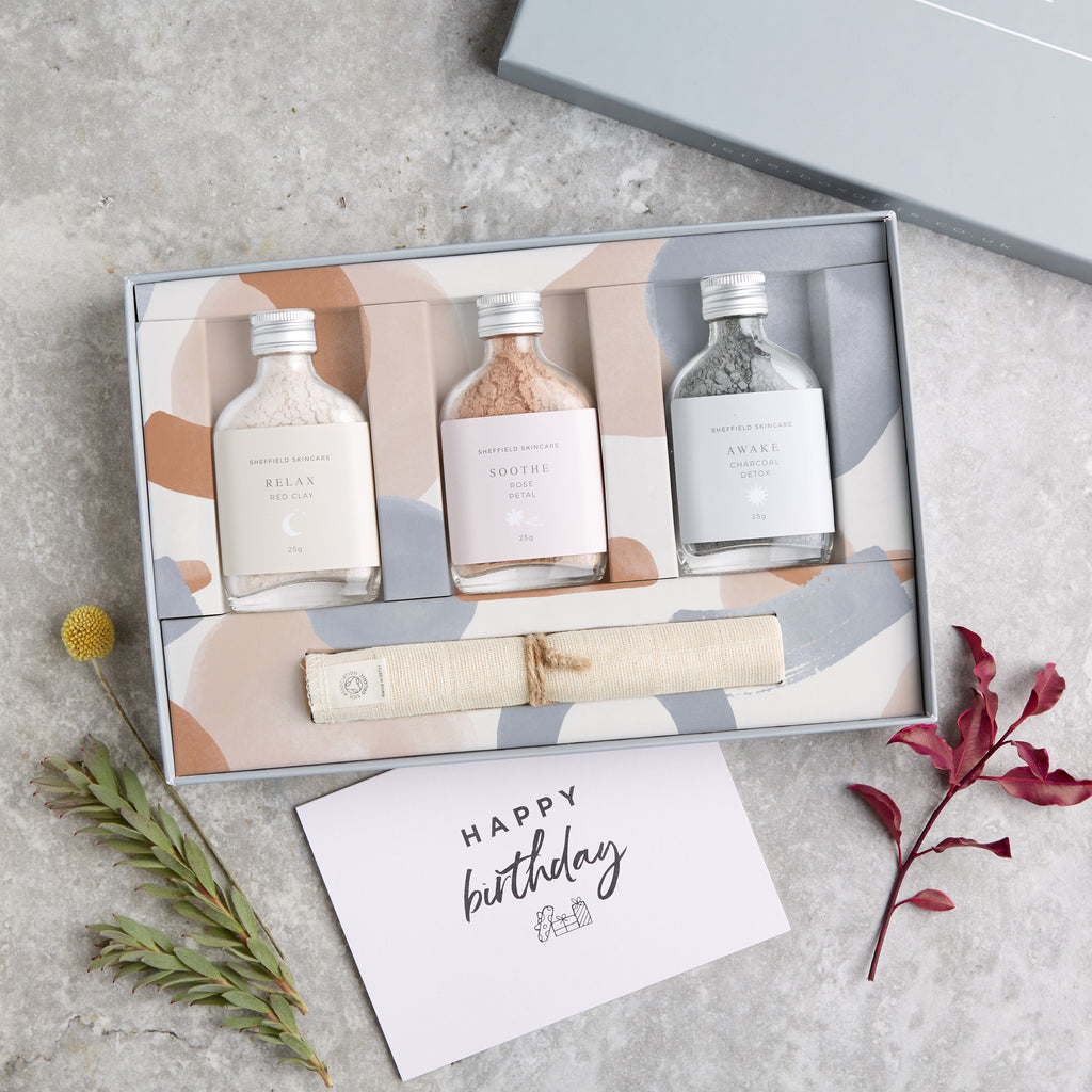 Facial spa gift set containing three clay face masks in glass bottles and muslin face cloth