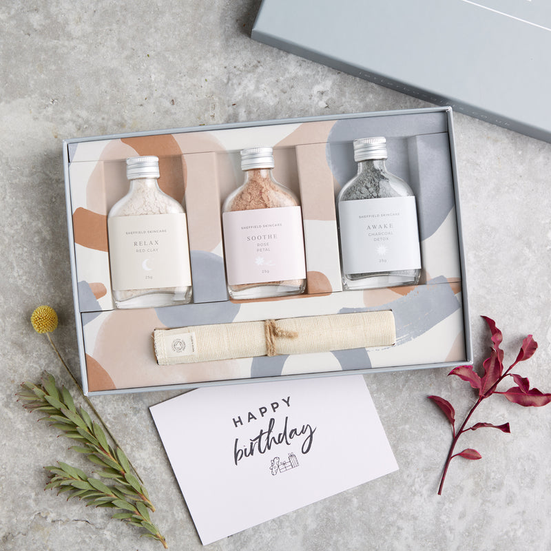Facial spa gift set containing three clay face masks in glass bottles and muslin face cloth