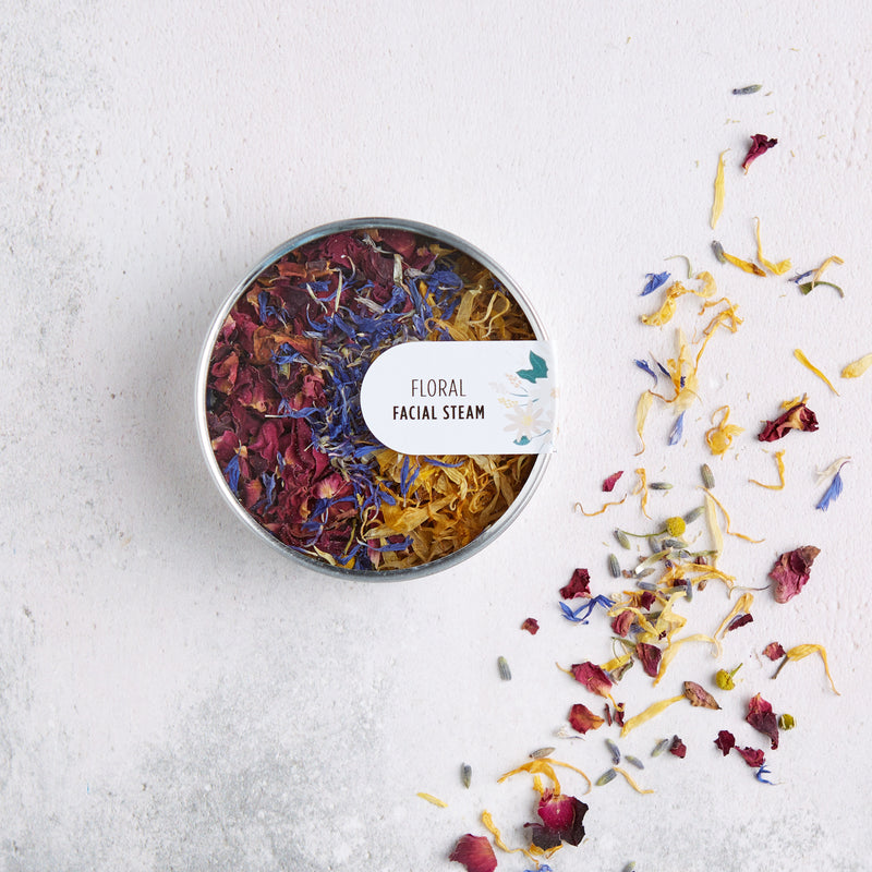 Floral facial steam tin containing red, blue and yellow flower petals