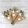 Three full sized neutral-tone dried flower bouquets wrapped in white tissue and Kraft cone