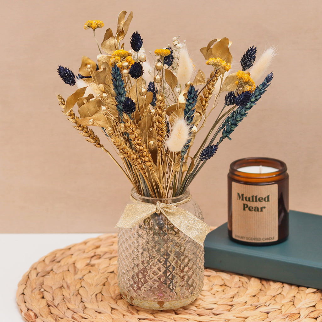 Gold, blue, yellow & white dried flower bouquet in a glass vase