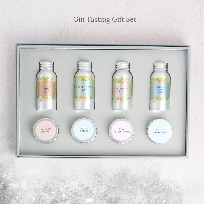 Gin tasting letterbox gift set containing four flavoured gins and four gin botanical tins