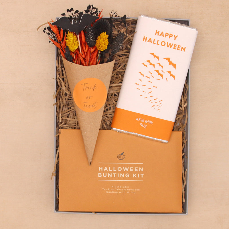 Halloween letterbox gift set containing happy halloween milk chocolate bar, halloween bunting kit and trick or treat orange and black dried flower posy