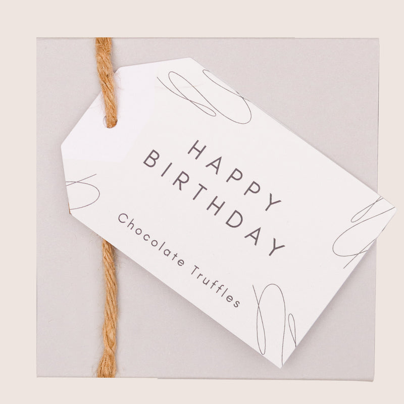 Butterscotch chocolate truffles in a grey box with happy birthday swing tag
