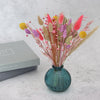 Dried flowers spring bouquet with pink, purple, yellow and natural flowers arranged in a green glass jar