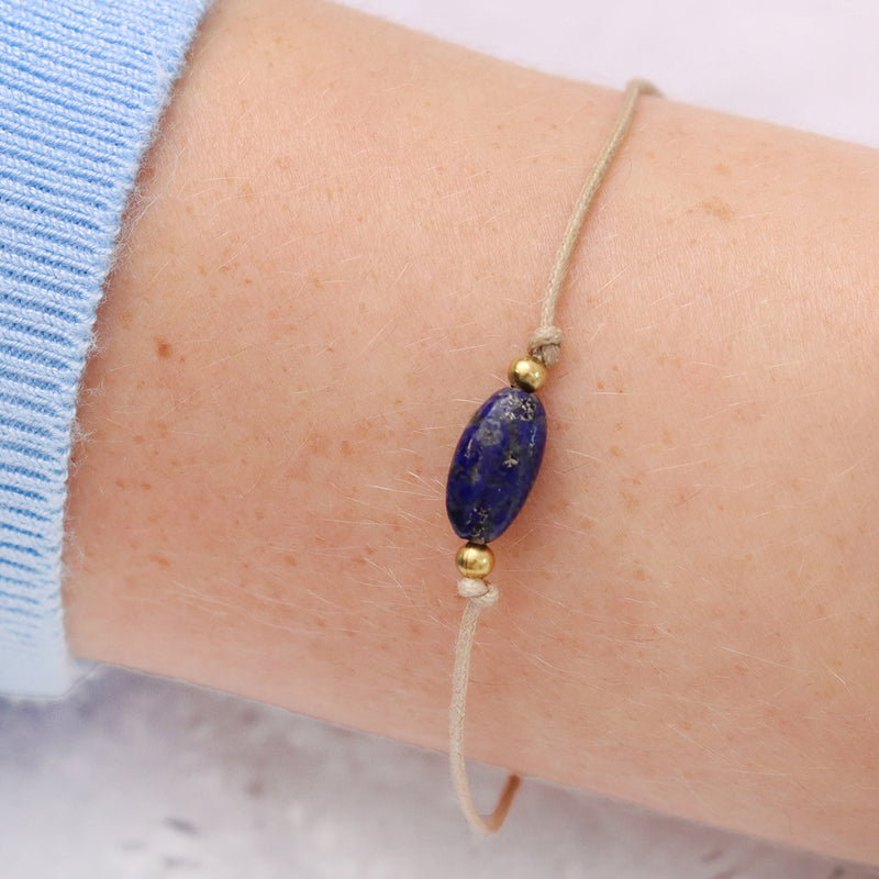Blue lapis lazuli gemstone bracelet being displayed on a persons wrist