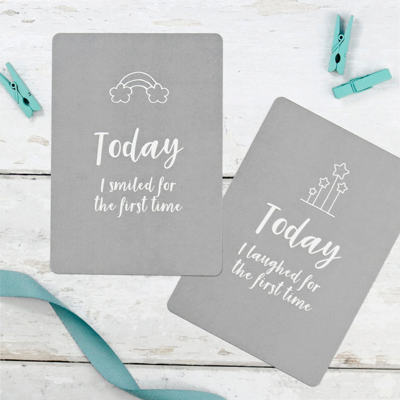 Grey baby milestone cards reading 'Today I smiled for the first time' and 'Today I laughed for the first time'