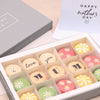 Fifteen mother's day macarons in pastel pink, green, yellow and cream, with 'i love you mum' printed text and white daisies
