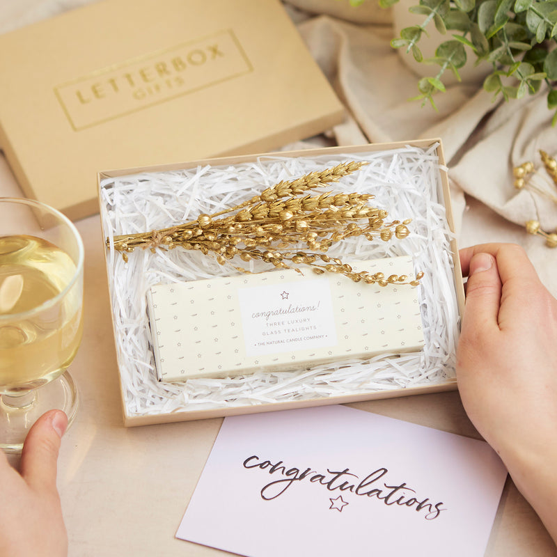 Mini congratulations letterbox gift set containing pastel yellow congratulations tealights & gold dried flower posy