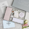 a mum's gin gift box with the lid off showing the contents of chocolate, salcombe gin, marvellous mum tealight box and Himalayan bath salts. next to a mother's day card