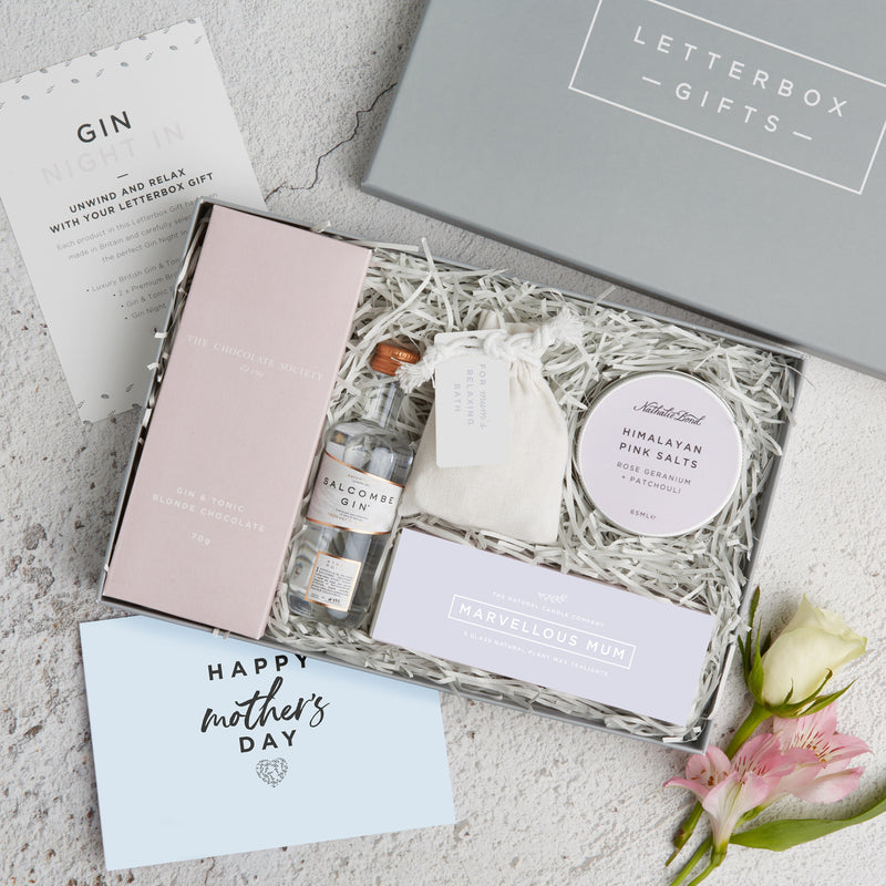 a mum's gin gift box with the lid off showing the contents of chocolate, salcombe gin, marvellous mum tealight box and Himalayan bath salts. next to a mother's day card