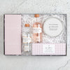 Letterbox Gin Lovers Gift set containing gin & tonic chocolate bar, two gin miniature bottles, gin botanicals tin and gin night in tealights in pink and white packaging