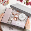 A person holding a Gin Lovers Letterbox Gift set  containing chocolate bar, two gin miniatures, gin botanicals tin and gin night in tealights