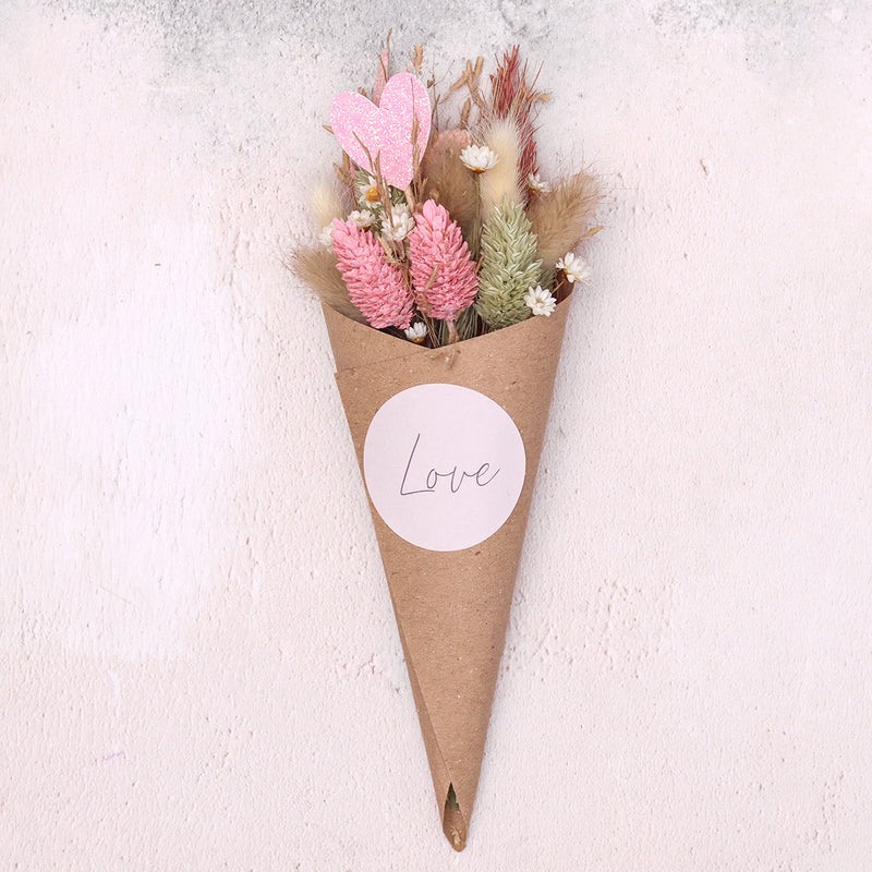 Valentine's day pink and neutral dried flower posy with love heart and 'love' sticker in a kraft cone