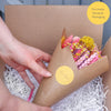 Pre-arranged bright summer dried flower bouquet with for you sticker being placed into a gift box