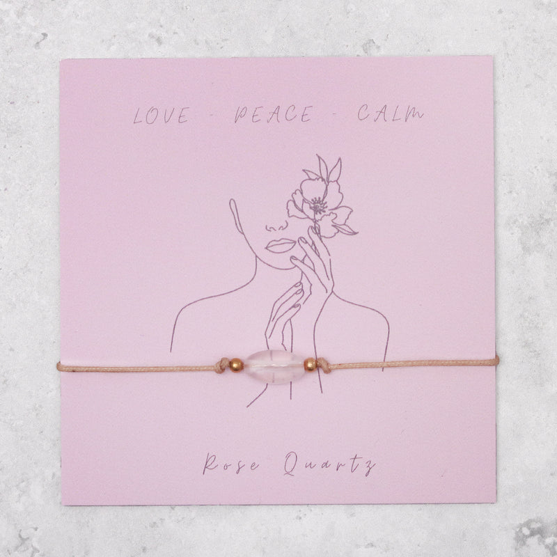 Rose quartz gemstone bracelet on pale pink card detailing the qualities love, peace and calm