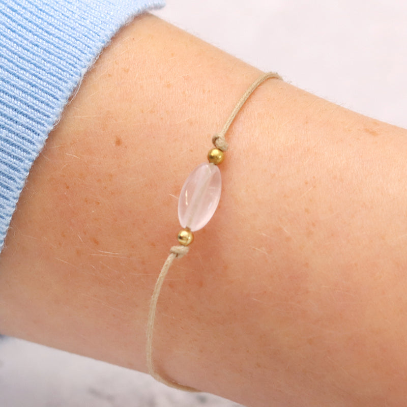 Rose quartz gemstone bracelet being displayed on a person's wrist