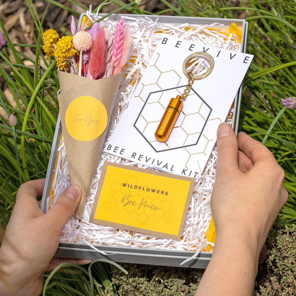 Summer bee letterbox gift set containing gold keyring bee revival kit, bee-friendly wildflower seeds and bright summer dried flower posy