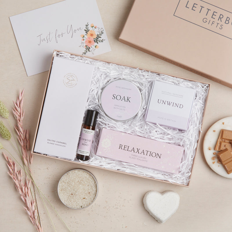 Spa Night In letterbox gift set in purple packaging, containing salted caramel chocolate bar, relaxation tealights, soak bath salts, unwind bath bomb & lavender oil roll on