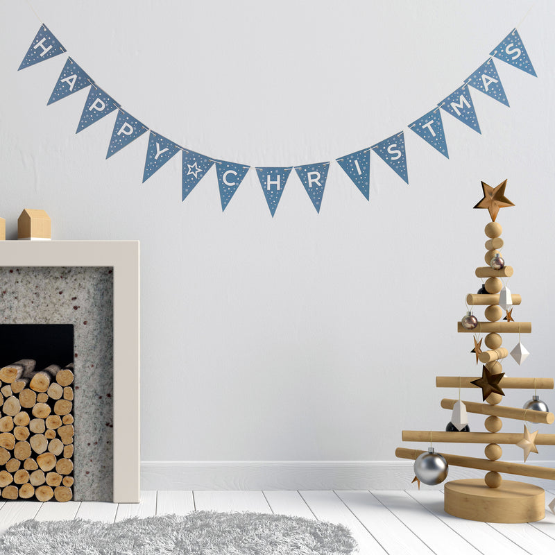 Happy Christmas bunting being displayed in on a lounge wall next to fireplace and wooden tree