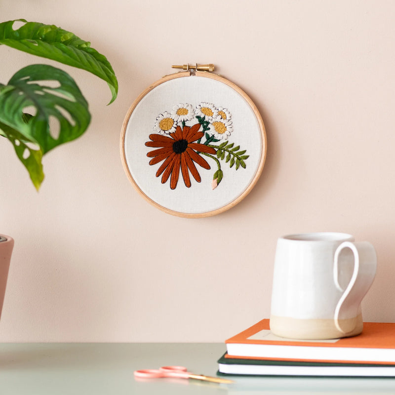 Round retro daisies embroidery hanging on a wall