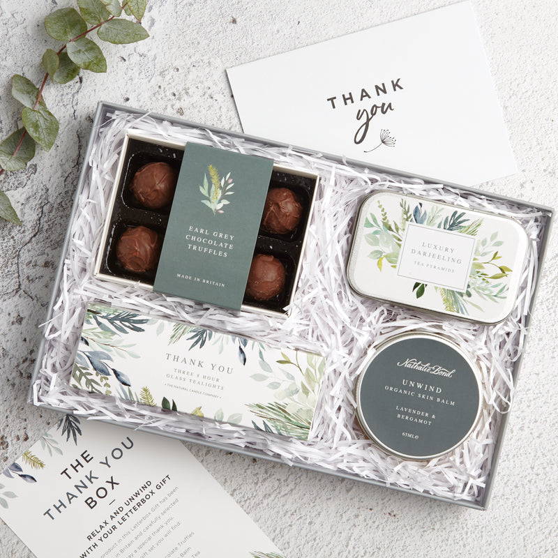Thank You letterbox gift set containing earl grey chocolate truffles, darjeeling tea tin, unwind skin balm & thank you tealights with 'Thank you' Greetings card