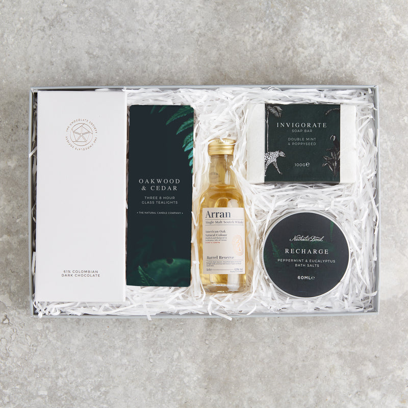 Letterbox-friendly 'man box' gift set containing dark chocolate, tealights, whisky miniature, soap and bath salts in dark green packaging