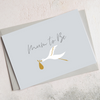 A6 greetings card with 'Mum to Be' text and white crane holding a gold baby bundle