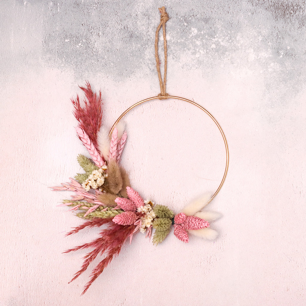 Pink, white and natural dried flower wreath on a gold hoop